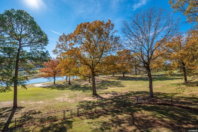 view of yard featuring a water view and fence