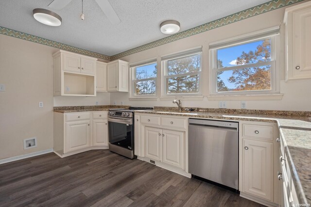 kitchen featuring dark wood-style floors, appliances with stainless steel finishes, white cabinetry, a sink, and a textured ceiling