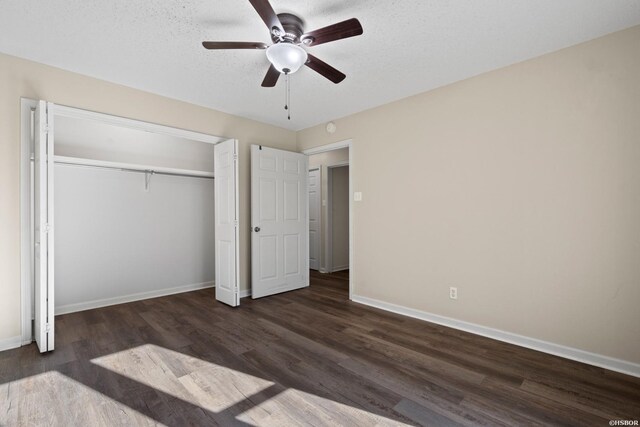 unfurnished bedroom featuring a textured ceiling, dark wood-type flooring, a ceiling fan, baseboards, and a closet