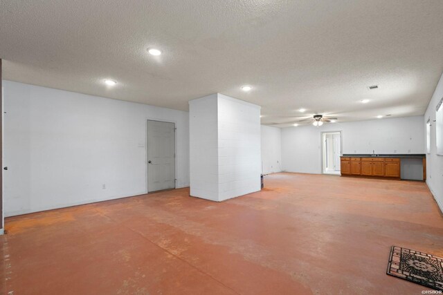 basement featuring a ceiling fan, recessed lighting, and a textured ceiling