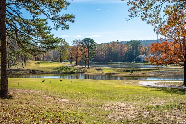 view of property's community with a water view and a yard