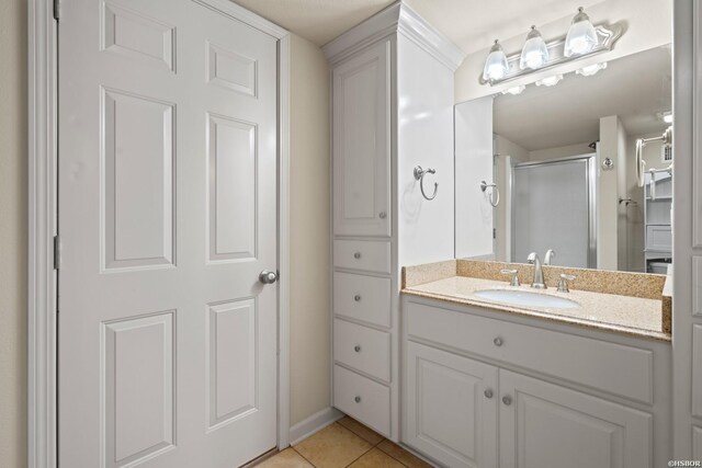 full bathroom featuring tile patterned flooring, vanity, and a shower stall