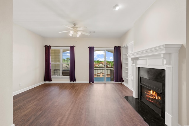 518 Amity Rd Unit E4, Hot Springs, AR 71913 - unfurnished living room with ceiling fan, baseboards, dark wood-style flooring, and a glass covered fireplace