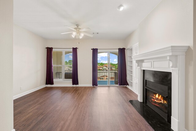 518 Amity Rd Unit E4, Hot Springs, AR 71913 - unfurnished living room with ceiling fan, baseboards, dark wood-style flooring, and a glass covered fireplace
