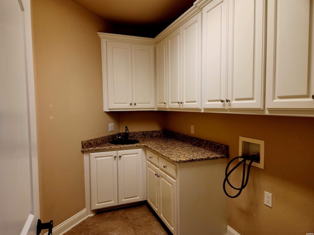 clothes washing area with cabinet space, tile patterned flooring, hookup for a washing machine, and baseboards