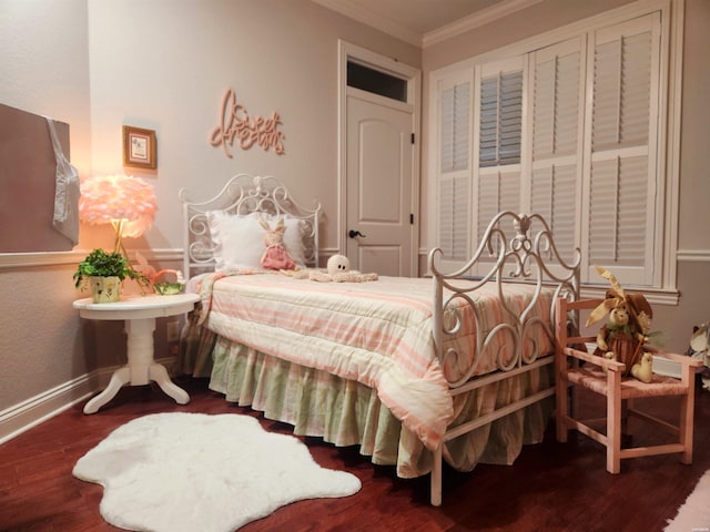 bedroom with wood finished floors, baseboards, and ornamental molding