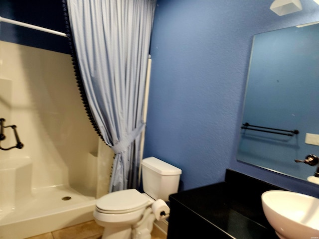 bathroom featuring tile patterned floors, toilet, a stall shower, a sink, and a textured wall