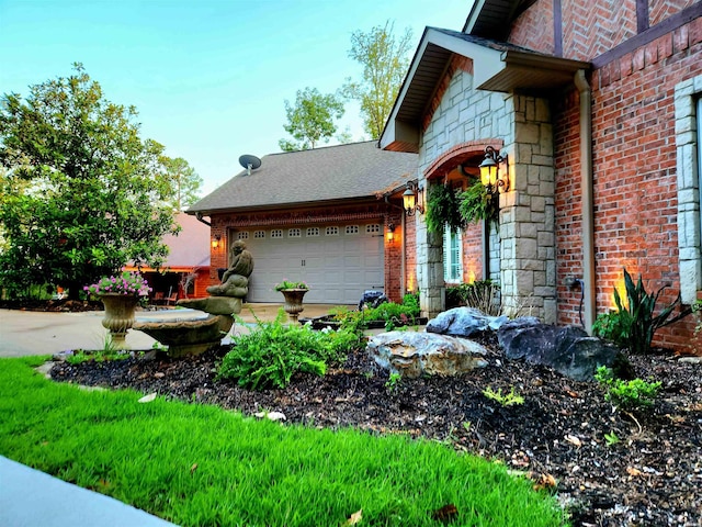 exterior space featuring a garage, brick siding, stone siding, and roof with shingles