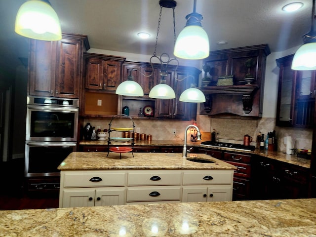 kitchen with light stone counters, stainless steel double oven, decorative backsplash, and a sink