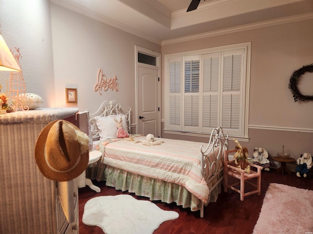 bedroom featuring ornamental molding, a raised ceiling, and wood finished floors