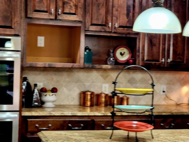 bar featuring stainless steel double oven and backsplash