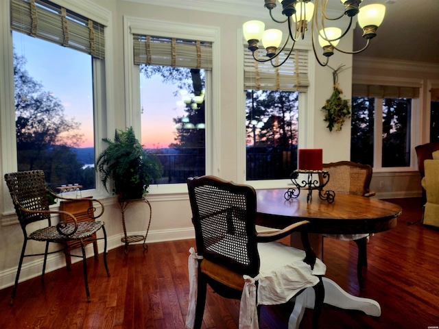 dining room with baseboards, wood finished floors, a chandelier, and ornamental molding