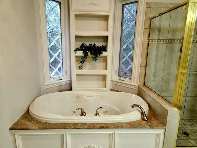 full bath with a wealth of natural light, a tub with jets, a shower stall, and built in shelves