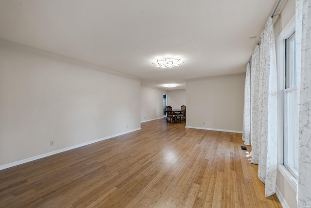 unfurnished room featuring light wood-type flooring and baseboards