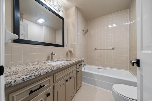 full bathroom featuring toilet, vanity, tub / shower combination, decorative backsplash, and tile patterned floors