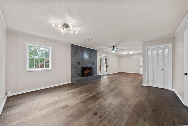 unfurnished living room featuring ornamental molding, a fireplace, a textured ceiling, and wood finished floors