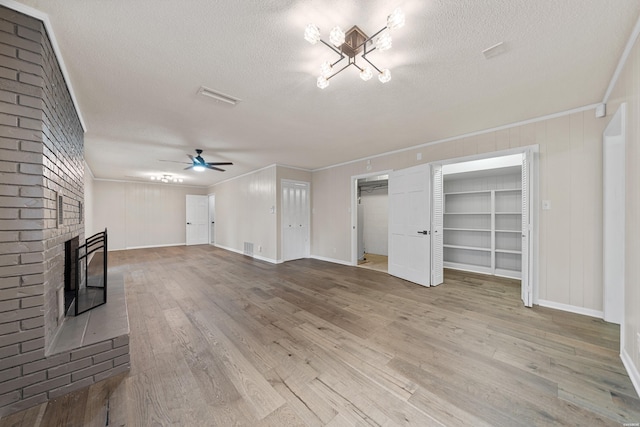 unfurnished living room with a fireplace, ornamental molding, and wood finished floors