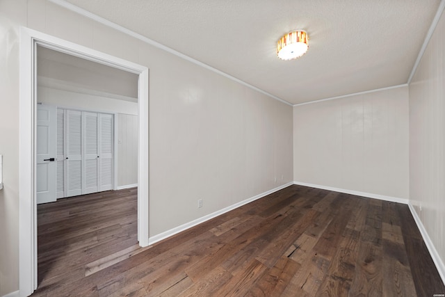 spare room with dark wood finished floors, crown molding, and a textured ceiling