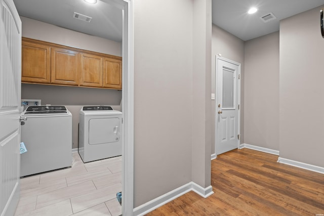 laundry room featuring washing machine and dryer, visible vents, and baseboards