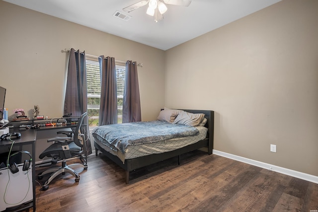 bedroom with ceiling fan, wood finished floors, visible vents, and baseboards