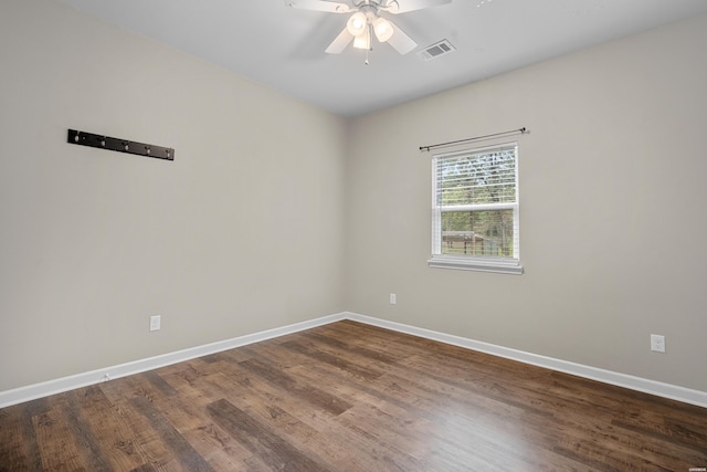 unfurnished room featuring dark wood-style floors, baseboards, visible vents, and a ceiling fan