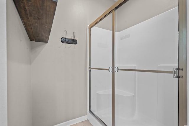 bathroom with a stall shower and baseboards