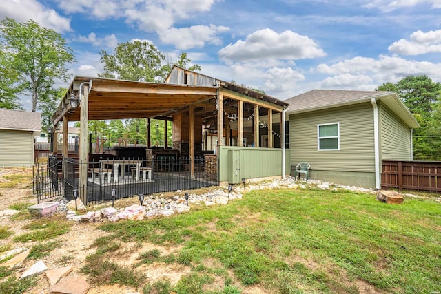 back of house featuring a yard and fence