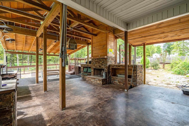 view of patio featuring an outdoor stone fireplace and fence