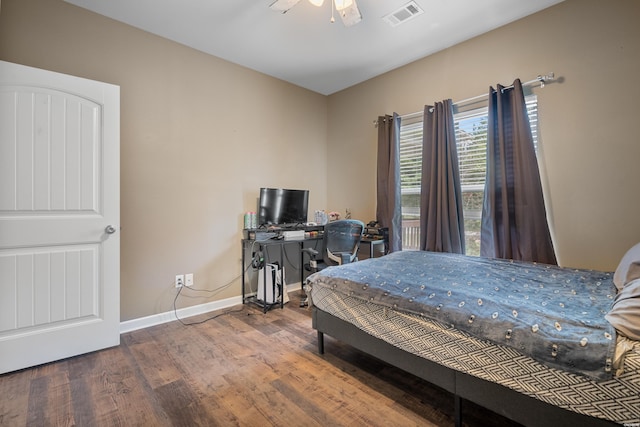 bedroom with visible vents, ceiling fan, baseboards, and wood finished floors