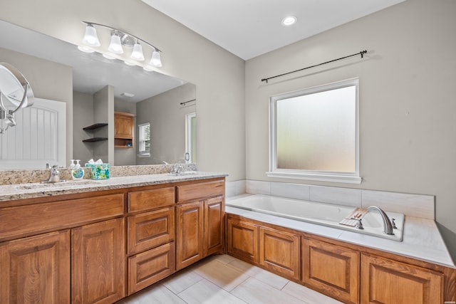 full bath with double vanity, tile patterned flooring, a sink, and a bath