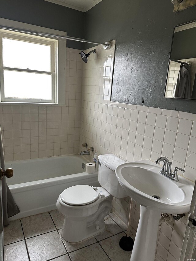 bathroom with a textured wall, tile patterned flooring, shower / tub combination, toilet, and tile walls