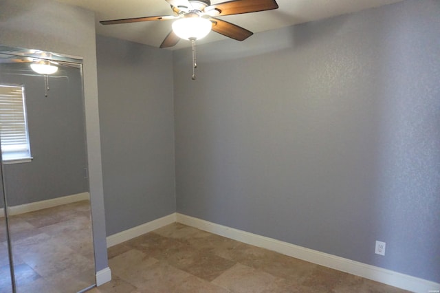 empty room featuring baseboards and ceiling fan