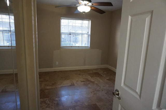 unfurnished room featuring baseboards and a ceiling fan