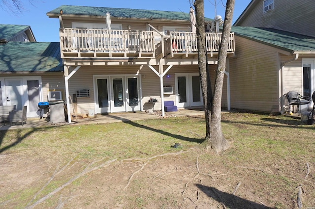 rear view of property featuring a lawn, french doors, and a wooden deck