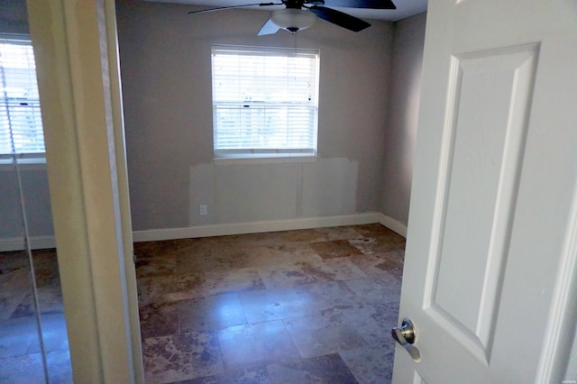 unfurnished bedroom featuring ceiling fan and baseboards