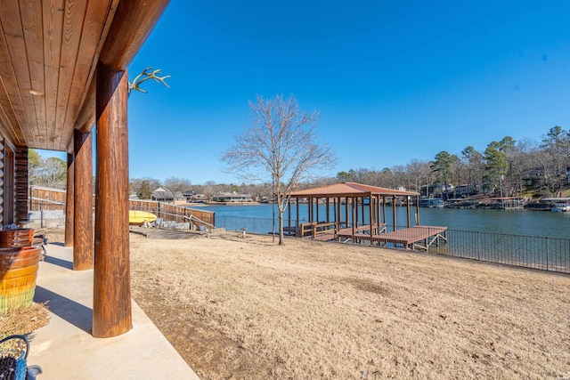 exterior space with a water view, fence, and a gazebo