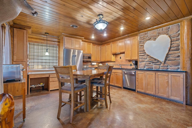 kitchen featuring light brown cabinets, appliances with stainless steel finishes, dark countertops, decorative light fixtures, and finished concrete floors