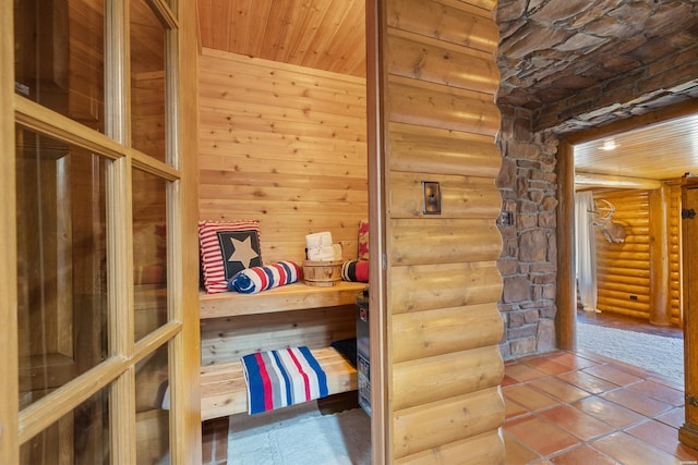 interior space with wooden ceiling and log walls