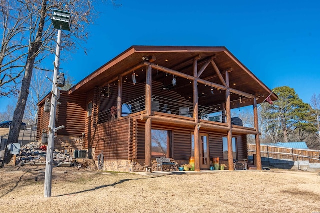 back of property featuring central air condition unit, a balcony, and log siding