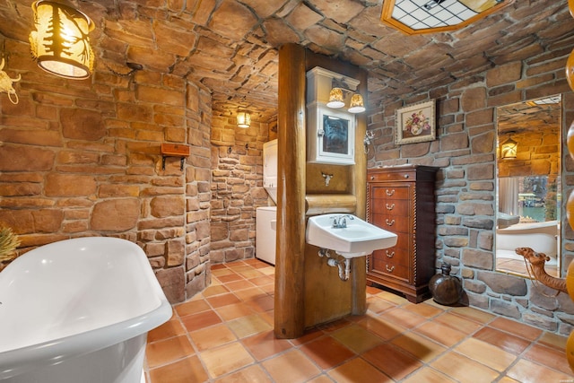 bathroom featuring a soaking tub and a sink