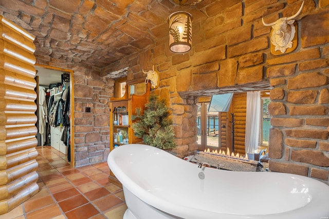 full bath featuring a soaking tub, tile patterned flooring, and log walls