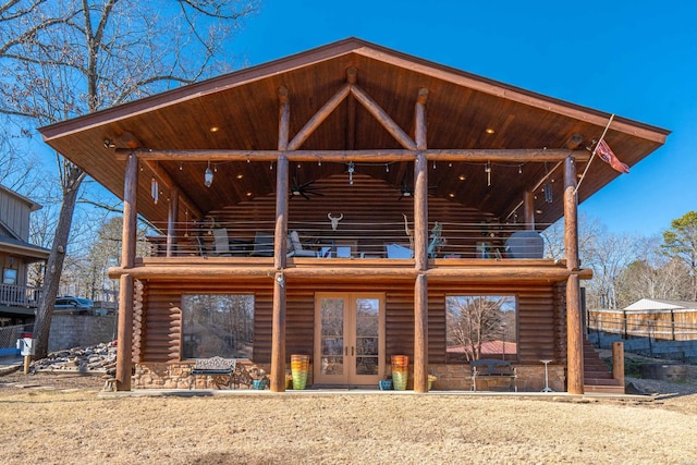 rear view of property featuring a balcony, log siding, and french doors