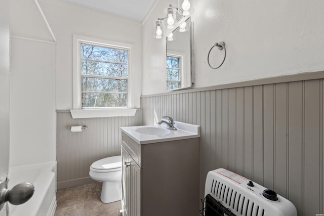 bathroom featuring a wainscoted wall, toilet, ornamental molding, heating unit, and vanity