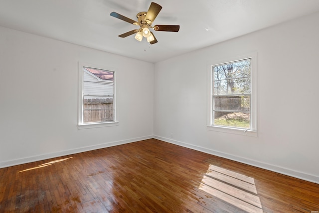 spare room with ceiling fan, baseboards, and hardwood / wood-style floors