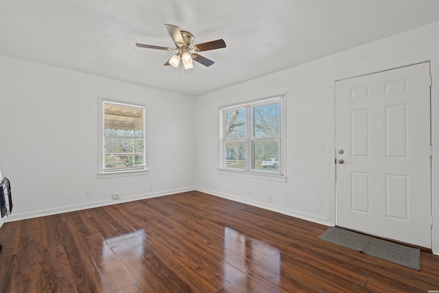 foyer entrance featuring dark wood-style floors, ceiling fan, and baseboards