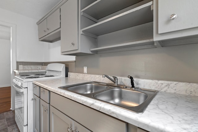 kitchen featuring gray cabinetry, open shelves, a sink, white electric stove, and light countertops