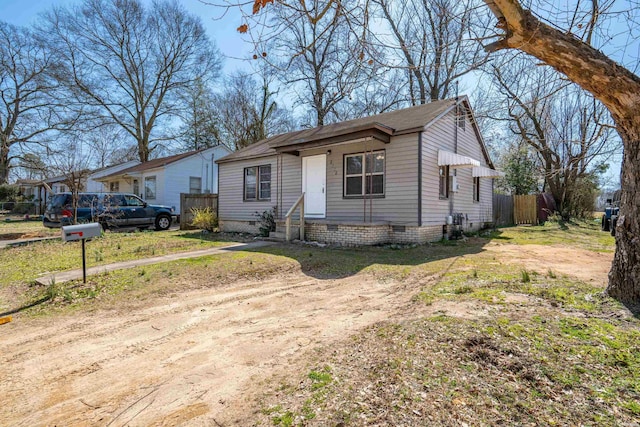 view of front of property featuring crawl space, entry steps, dirt driveway, and fence