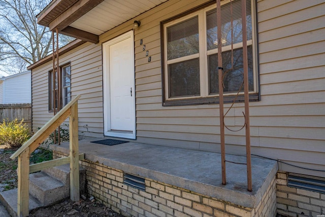 doorway to property featuring fence