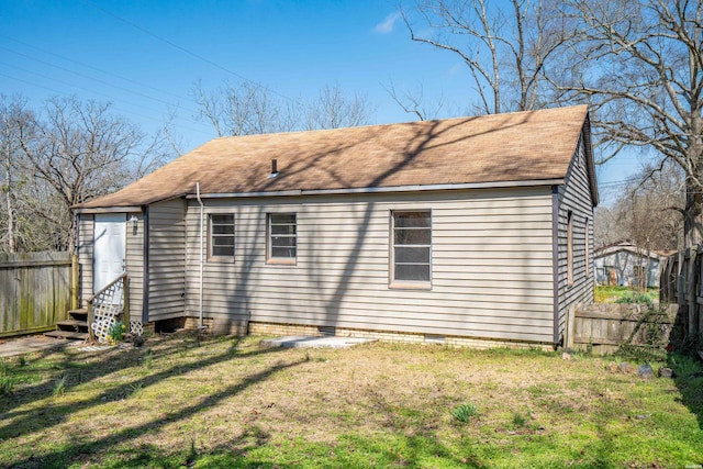 rear view of property with crawl space, fence, a lawn, and entry steps