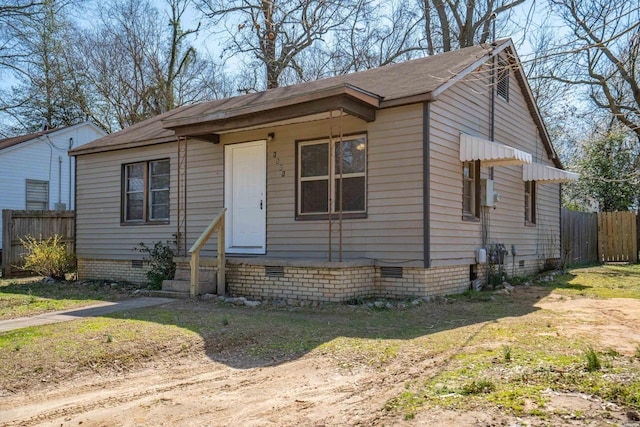 bungalow-style house with fence and crawl space